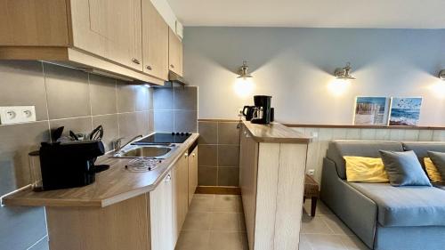 une petite cuisine avec un évier et un canapé dans l'établissement Argousiers 12, à Fort-Mahon-Plage