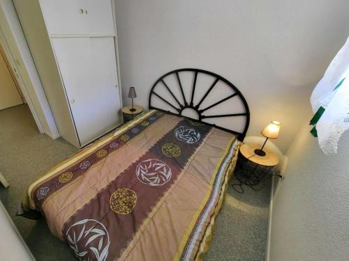 - une chambre avec un lit doté d'un grand couvre-lit dans l'établissement T2 charmant pour 4 personnes avec piscine, parking, proche plage et commerces - FR-1-607-54, au Cap d'Agde