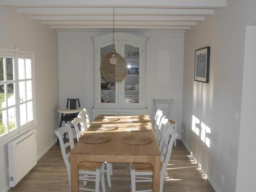 une salle à manger avec une table en bois et des chaises blanches dans l'établissement Longère rénovée proche Palais avec jardin, 5 chambres, 3 salles de bain, WIFI, idéale famille - FR-1-418-179, au Palais