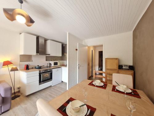 Il dispose d'une cuisine et d'un salon avec une table en bois et une salle à manger. dans l'établissement Super Venosc - E3 - Studio vue montagne 4pers, à Les Deux Alpes