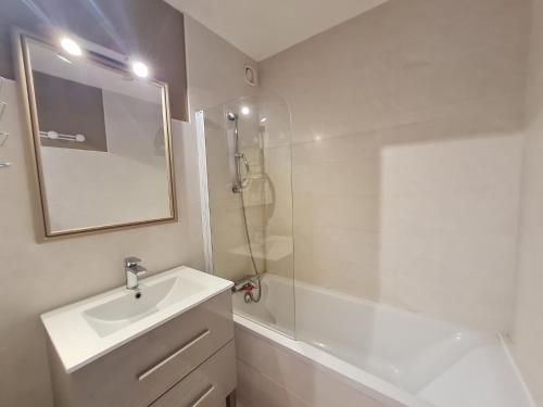 une salle de bain blanche avec un lavabo et une douche dans l'établissement Super Venosc - E3 - Studio vue montagne 4pers, à Les Deux Alpes
