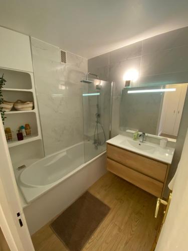 a bathroom with a tub and a sink and a shower at Appartement Moderne 2 chambres Proche Paris in Meudon