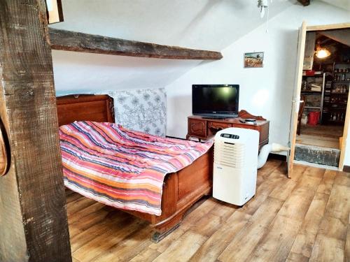 a bedroom with a bed and a computer on a wooden floor at Appartement près des Cévennes avec terrasse in La Grand-Combe