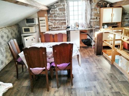 une cuisine avec une table et des chaises dans une pièce dans l'établissement Maison conviviale près des Cévennes avec terrasse, à La GrandʼCombe