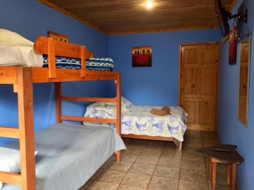 a bedroom with two bunk beds and a door at Manakin Lodge, Monteverde in Monteverde Costa Rica