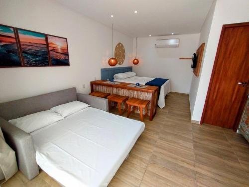 a room with a bed and a table in it at Villa Bangalu Exclusiva para Adultos in Porto De Galinhas