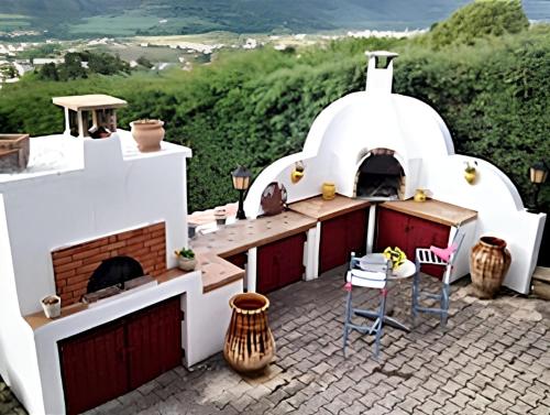 una cocina al aire libre con horno de pizza en un patio en Maison de 2 chambres avec piscine privee et jardin clos a Veyras en Veyras
