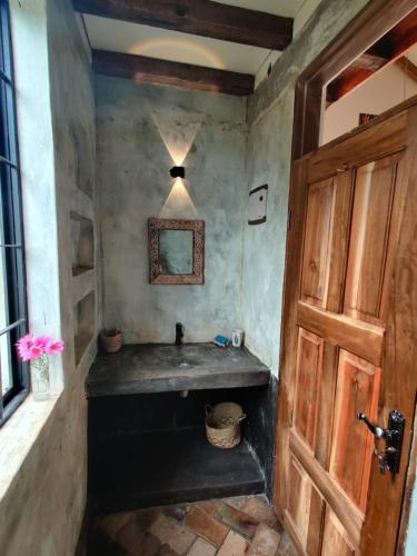 baño con lavabo y puerta de madera en Harry's Cabin - Overlooking Lake Victoria - 30 min from Jinja, en Jinja