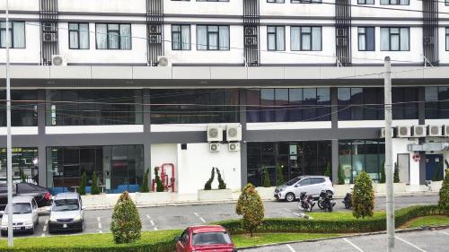 a large white building with cars parked in front of it at Sibu T1 Homestay, 4 Bedrooms in Sibu