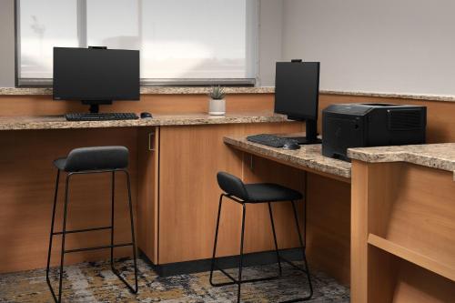 two desks with two monitors and two bar stools at TownePlace Suites by Marriott Cheyenne Southwest/Downtown Area in Cheyenne
