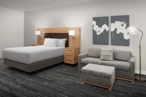 a bedroom with a bed and a couch and a chair at TownePlace Suites by Marriott Cheyenne Southwest/Downtown Area in Cheyenne