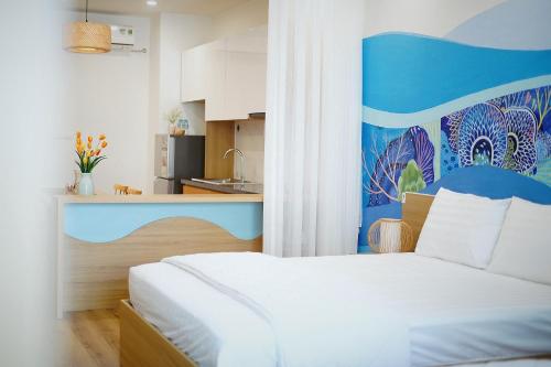 una camera con un letto bianco e una parete blu di Song Suoi Quy Nhon Beachfront Apartment a Quy Nhon