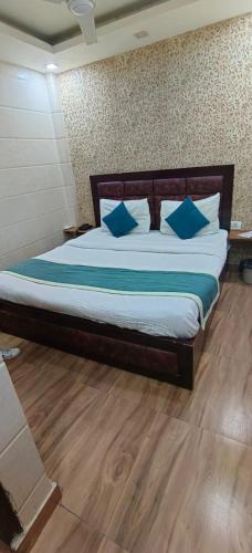 a bedroom with a large bed with blue pillows at Hotel the Height kalkaji in New Delhi