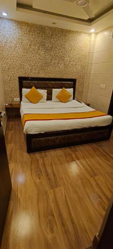 a bedroom with a bed with yellow pillows on it at Hotel the Height kalkaji in New Delhi