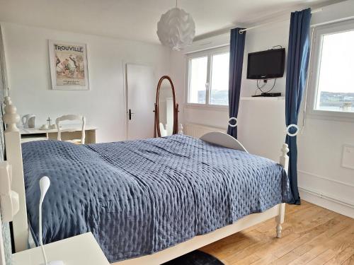 una camera con letto e piumone blu di La fleur du soleil a Trouville-sur-Mer