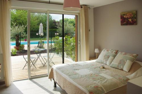 een slaapkamer met een bed en een glazen schuifdeur bij Les Abris Du Château in Mer