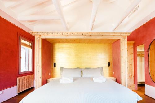 a large white bed in a room with red walls at Appartamento di lusso con terrazza sull'acqua in Venice