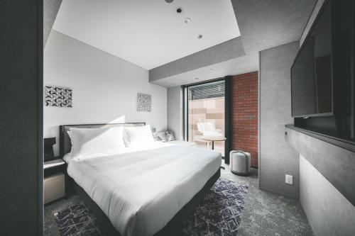 a bedroom with a large white bed and a window at SAPPORO STREAM HOTEL in Sapporo