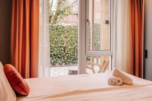 a bedroom with a bed and a window with a towel at Hotel Keur in Zandvoort