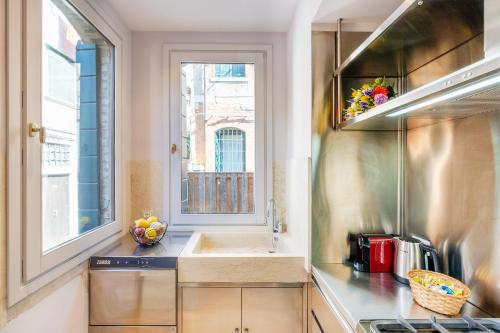 a kitchen with a sink and a window at Appartamento di lusso con terrazza sull'acqua in Venice