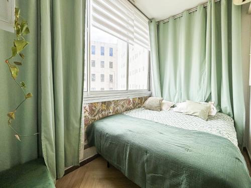 - une chambre avec un lit et une fenêtre avec des rideaux verts dans l'établissement Nice Plage - Wifi, AC, hyper centre, 4 pers, à Nice