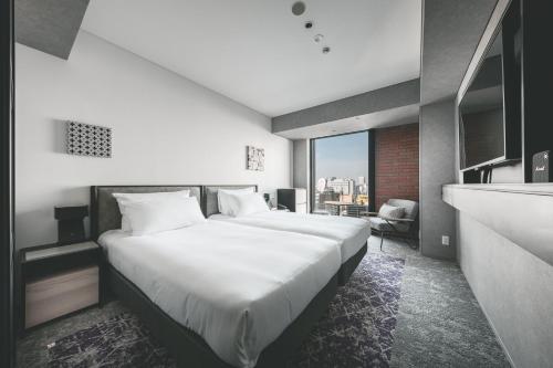 札幌SAPPORO STREAM HOTEL的卧室里有一张白色的大床，床边有一扇窗户