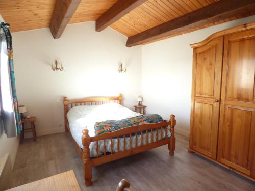 ein Schlafzimmer mit einem Bett und einem Holzschrank in der Unterkunft La grande Seibel in Les Bussolleries
