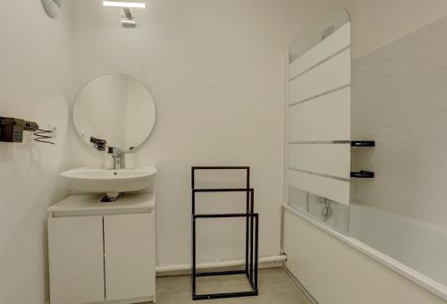 ein Bad mit einem Waschbecken und einem Spiegel in der Unterkunft Le Pasteur - LeBlanc Mesnil in Le Blanc-Mesnil