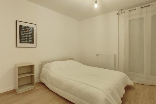 ein weißes Schlafzimmer mit einem Bett und einem Fenster in der Unterkunft Le Pasteur - LeBlanc Mesnil in Le Blanc-Mesnil