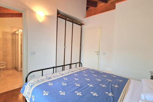 a bedroom with a bed with a blue comforter at Appartamenti Benaco in Peschiera del Garda
