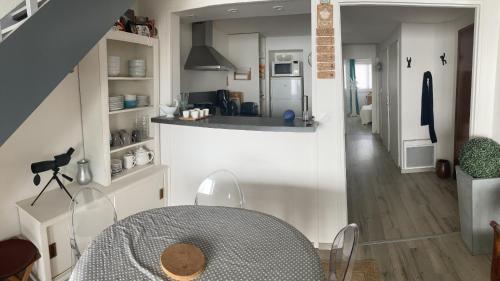 eine Küche und ein Esszimmer mit einem Tisch im Zimmer in der Unterkunft Appartement face mer PROCHE PLAGE in Les Sables-dʼOlonne