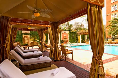 an outdoor patio with chairs and a swimming pool at Hotel Granduca Houston in Houston