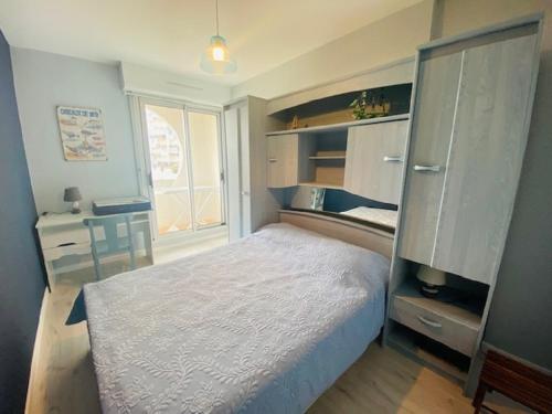 une chambre avec un lit blanc et un bureau dans l'établissement L'Escadrille, à Saint-Gilles-Croix-de-Vie