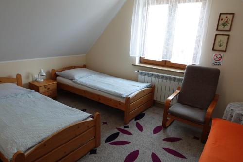 1 Schlafzimmer mit 2 Betten, einem Stuhl und einem Fenster in der Unterkunft Mała Chatka in Krzeszów