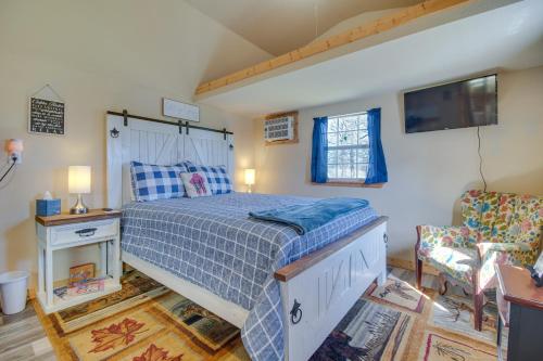 um quarto com uma cama e uma cadeira em Countryside Tiny Home in Cameron about 5 Mi to Poteau! 
