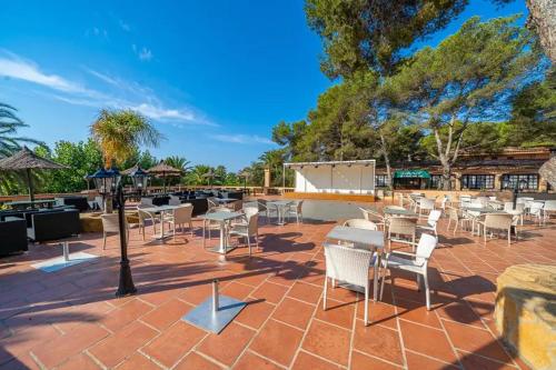 a patio with tables and chairs on a brick ground at Camping La Torre del Sol - Maeva Vacansoleil in Miami Platja