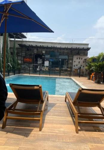 two chairs and an umbrella next to a swimming pool at Hotel Alessio in Bucaramanga