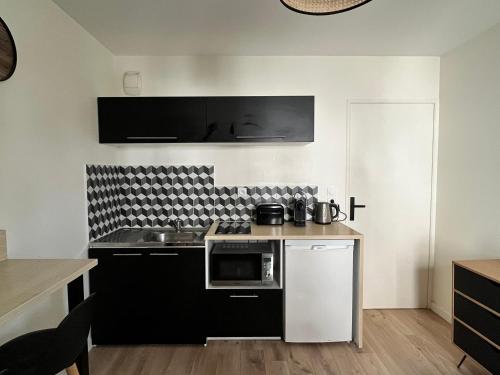 a kitchen with a sink and a microwave at Agréable Studio Calme - Proche Tramway et Centre in Nantes