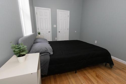 a bedroom with a bed with a black blanket at Mins to NYC - Stylish 3 Bedroom Haven in Jersey City