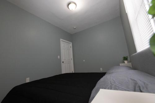 a bedroom with a bed and a window at Mins to NYC - Stylish 3 Bedroom Haven in Jersey City