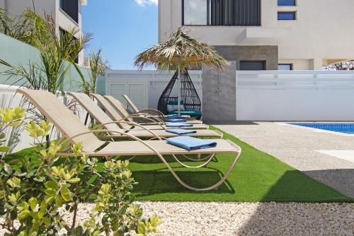 プロタラスにあるVilla Taliaのプールサイドのラウンジチェアのグループ