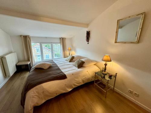 une chambre avec un grand lit et une fenêtre dans l'établissement La petite Maison chaleureuse, à Jouars-Pontchartrain