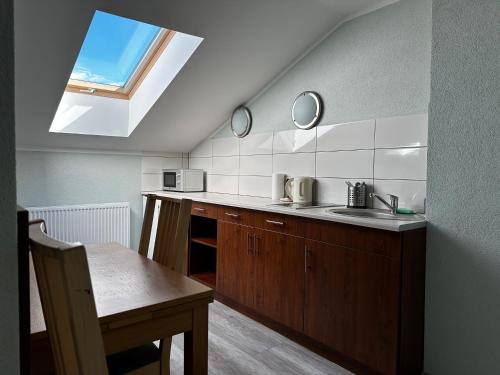 a kitchen with a sink and a skylight at Apartament Serwis in Krakow