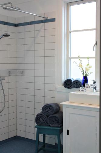 a bathroom with a shower with black towels on a stool at Rosenhøj Bed and Breakfast in Svendborg