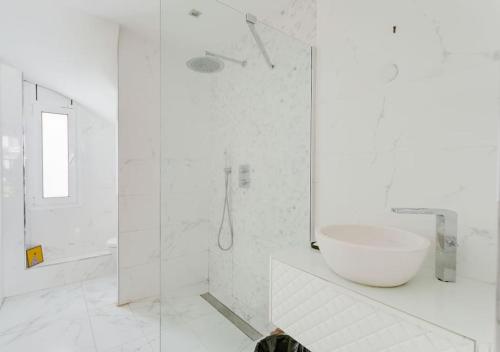 a white bathroom with a sink and a shower at Promenade dans La Mouzaïa in Paris