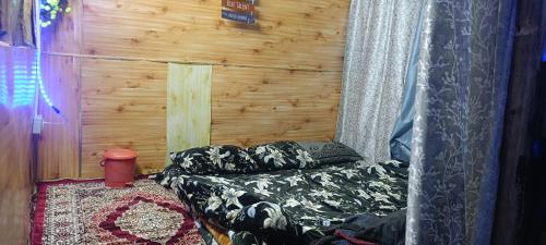 Habitación con cama y pared de madera. en Magical Tribe Malana, en Malāna