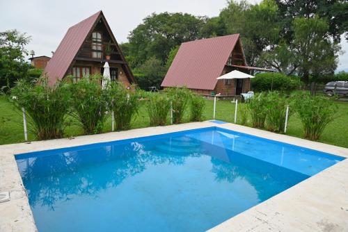 a house with a blue swimming pool in front of it at LA SERAFINA in Chicoana