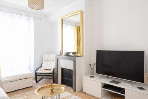 un salon avec une télévision et une cheminée dans l'établissement Apt near Montmartre and Pigalle, à Paris