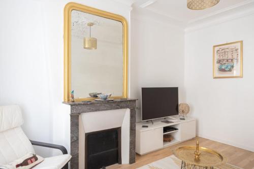 un salon avec une cheminée et un miroir dans l'établissement Apt near Montmartre and Pigalle, à Paris
