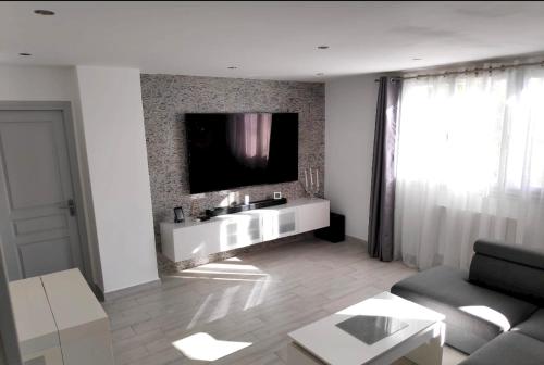 un salon avec une télévision à écran plat sur un mur dans l'établissement Appartement moderne à Uzès, 70 m², proche centre-ville, à Uzès